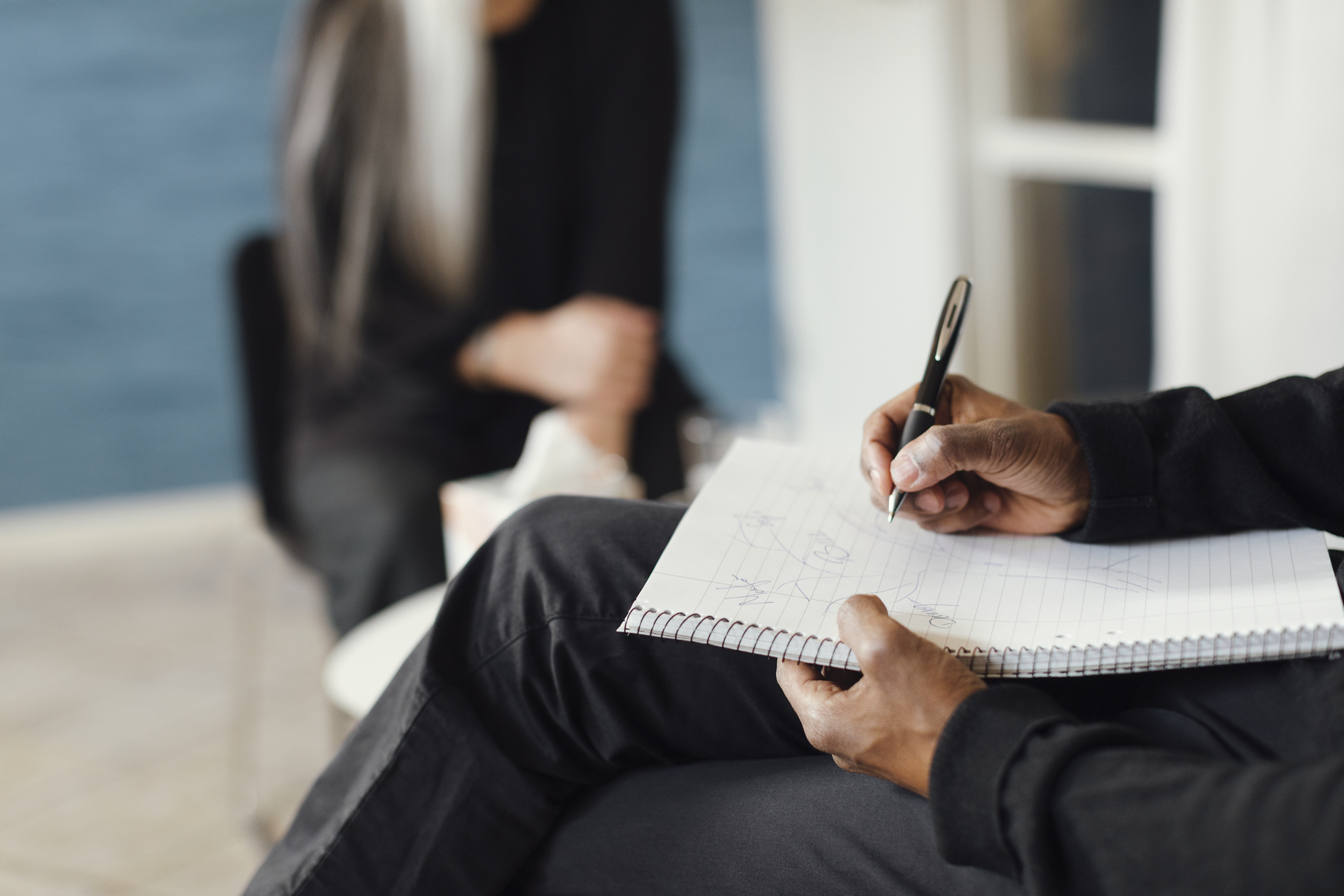 Bild på person som antecknar i skrivblock