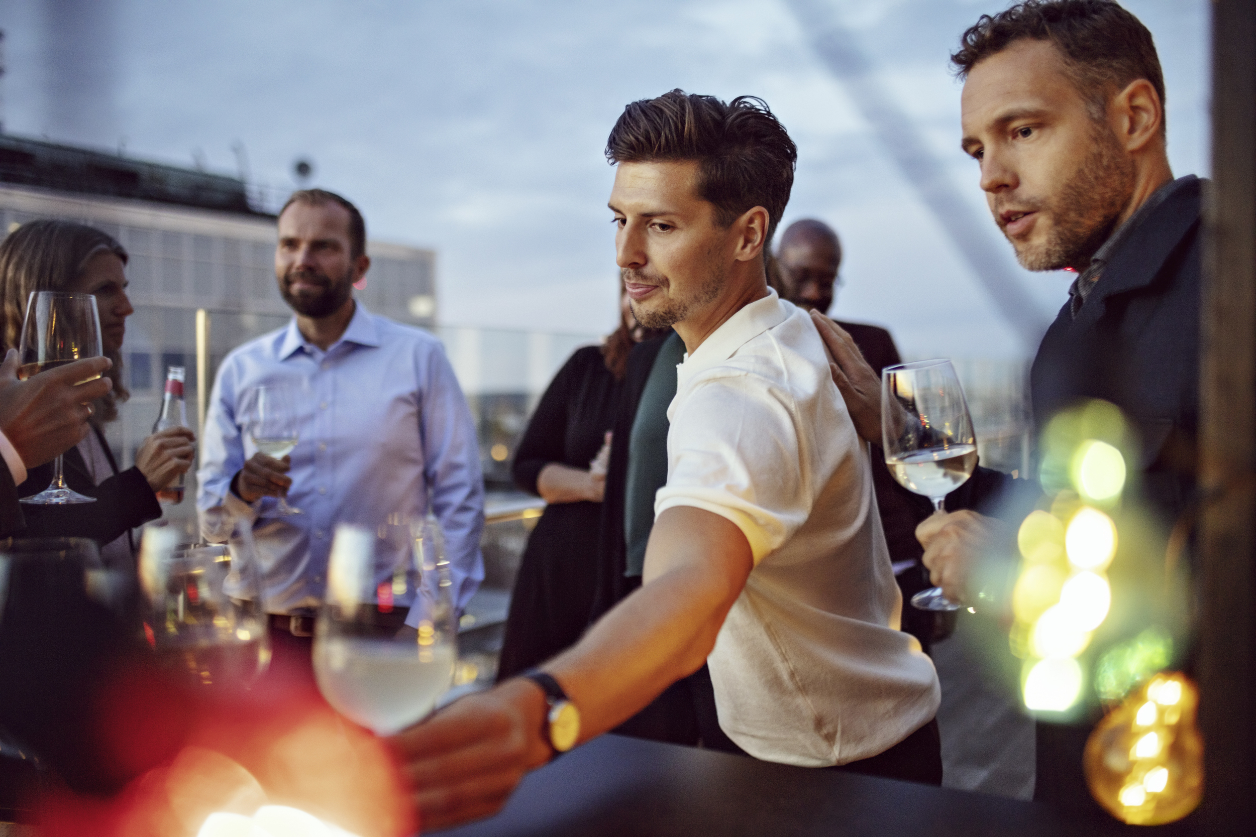 Manliga och kvinnliga kollegor dricker vin och firar.