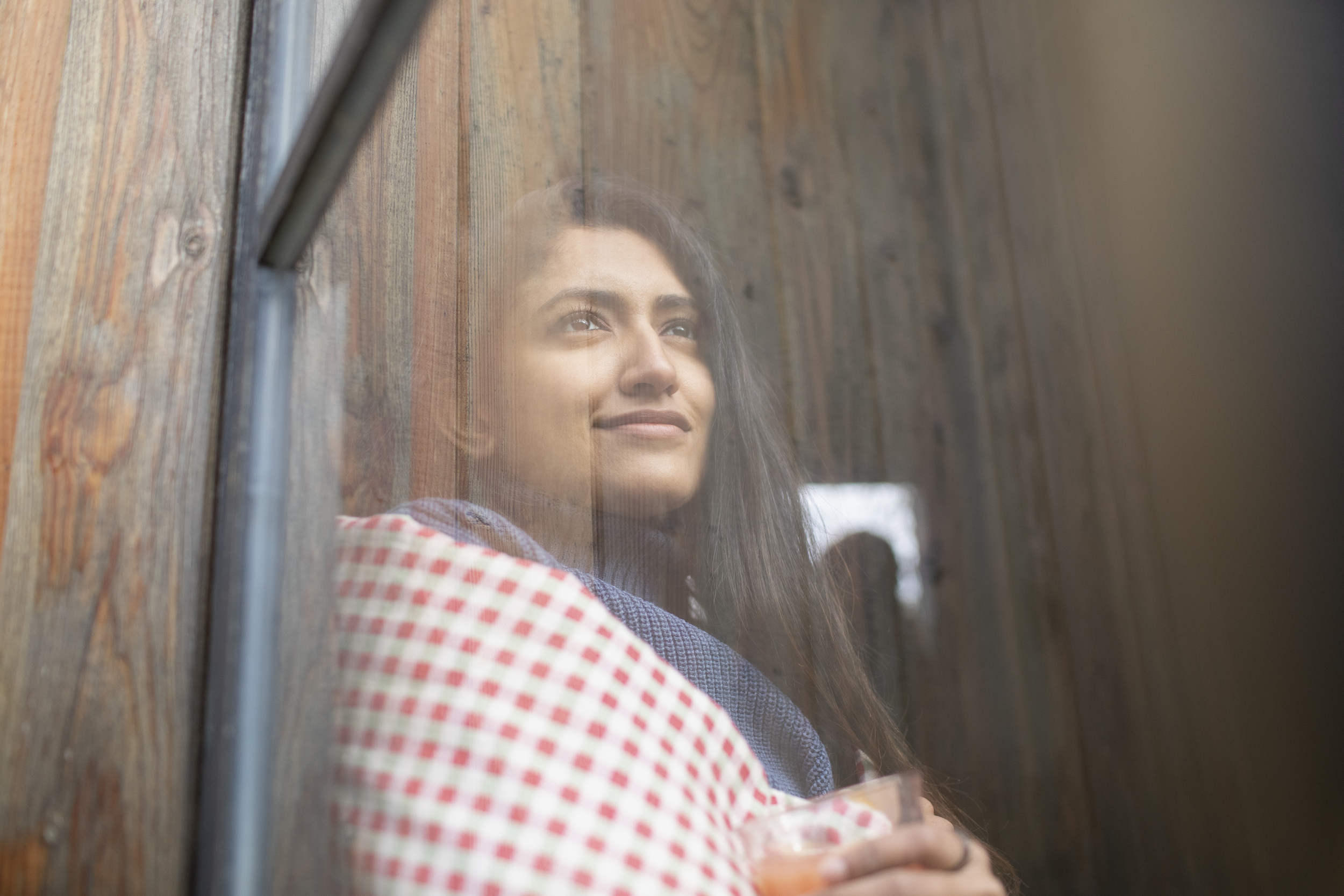 Kvinna ser ut genom fönster.