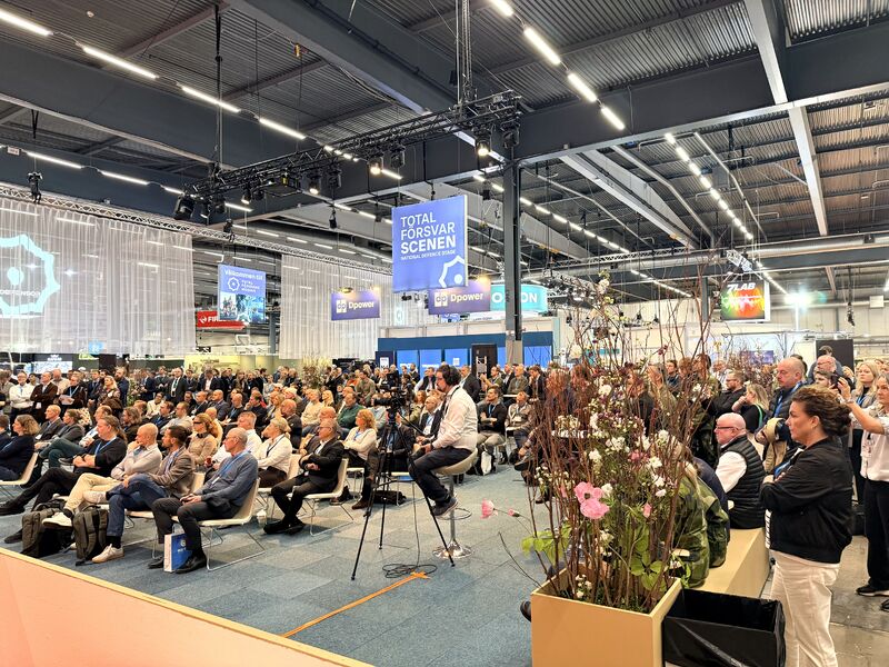Stor sittande och stående publik framför Totalförsvarsscenen under panelsamtalet om att skydda Sverige i fred, kris och krig.